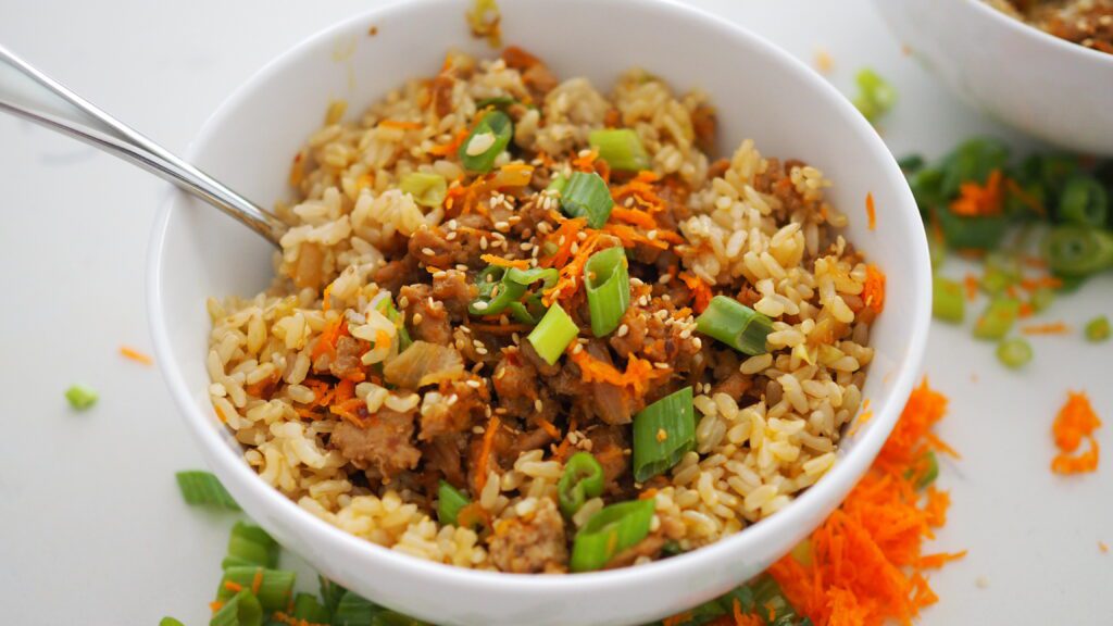 A bowl filled with hoisin turkey and brown rice