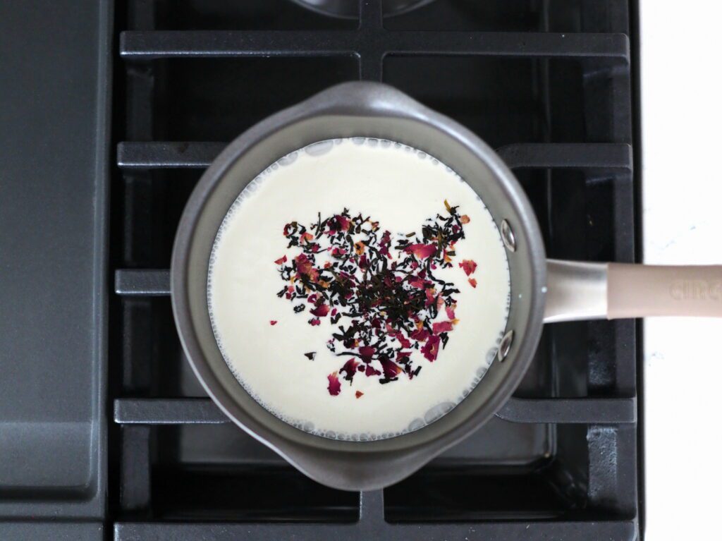 Rosy earl grey tea in a saucepan simmering with heavy cream.