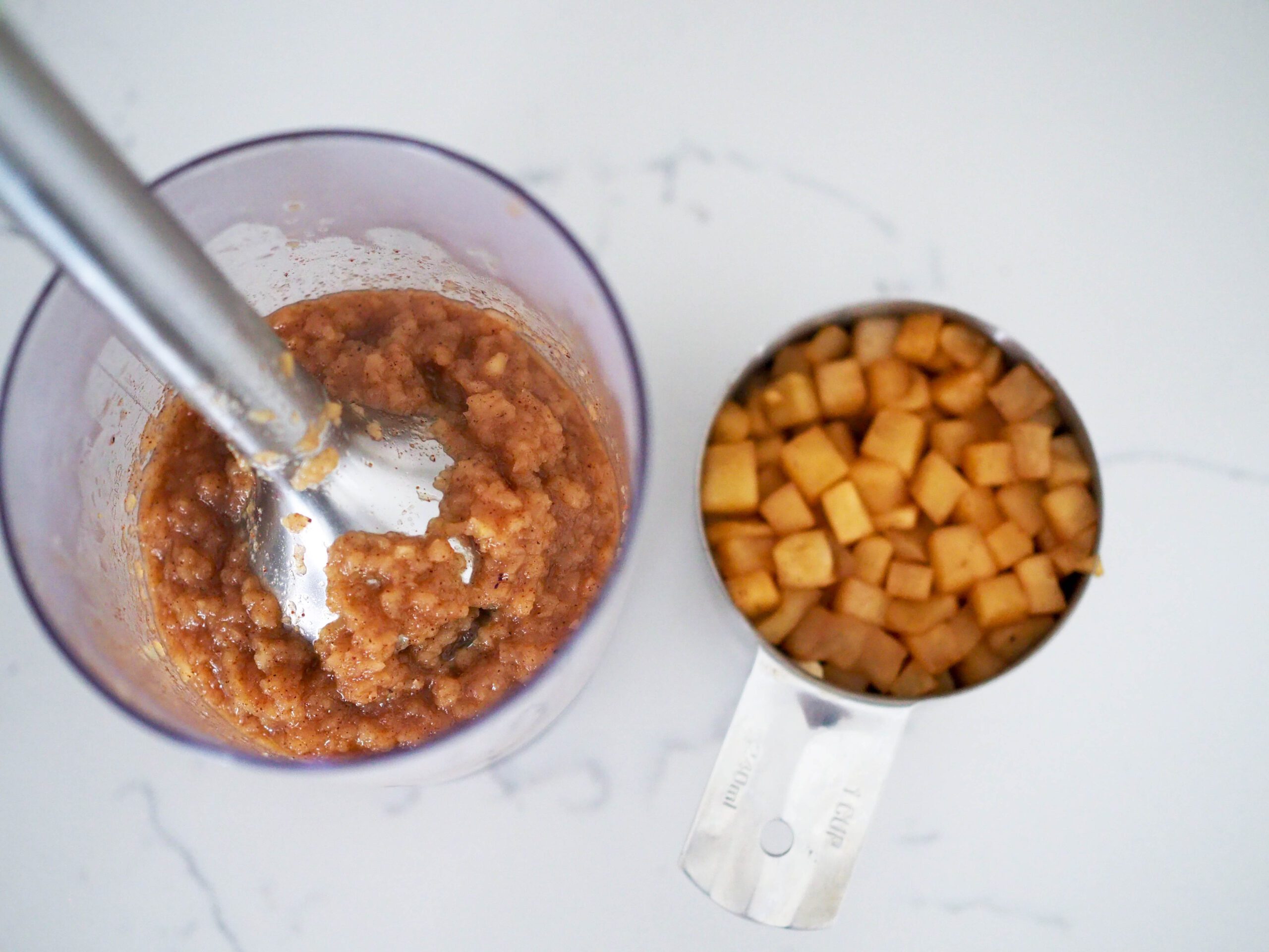 A chunky apple butter on the left, and a cup of diced and spiced apples on the right.