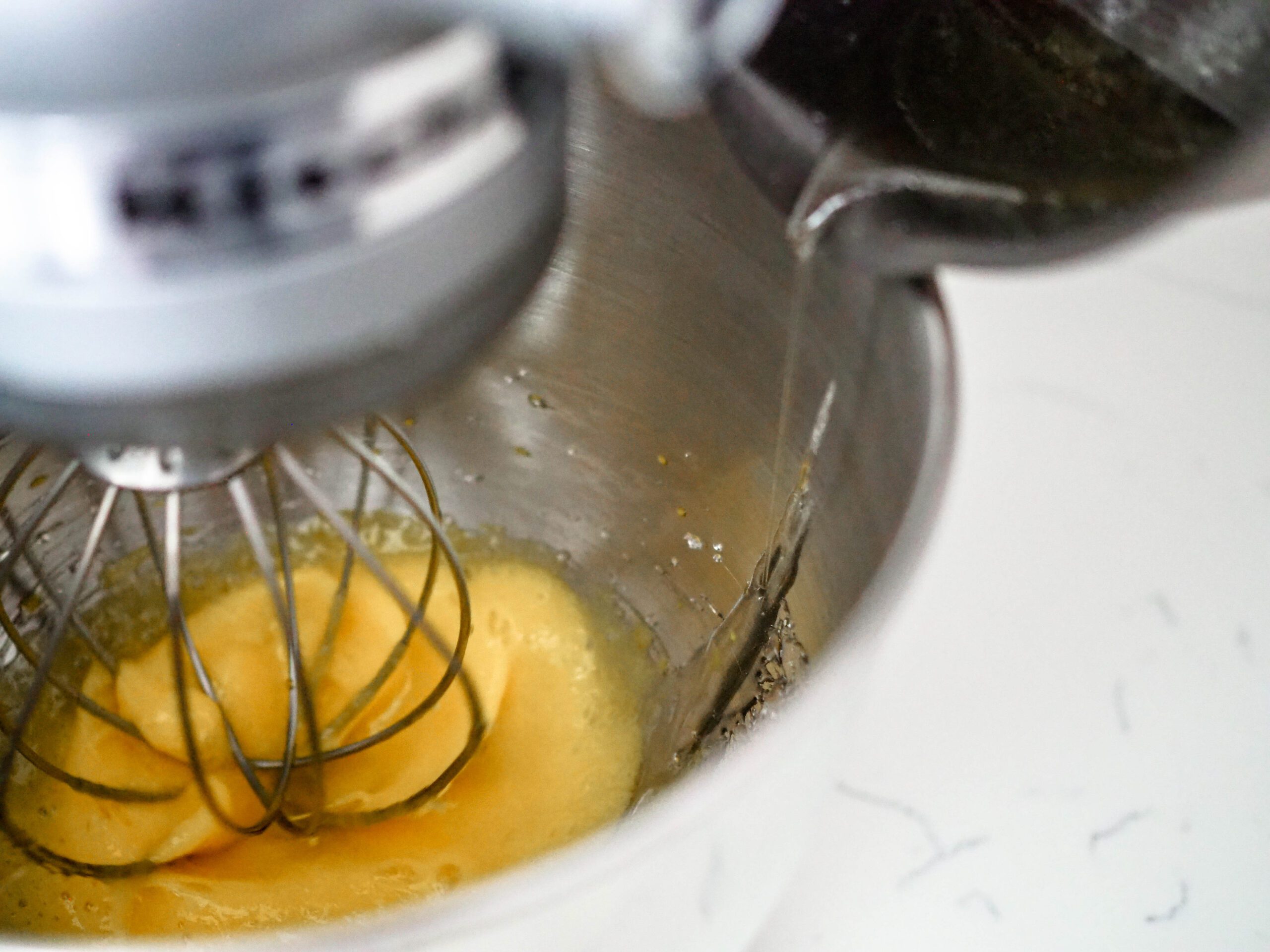 Sugar syrup is poured on the side of the stand mixer bowl instead of directly onto the whisk.