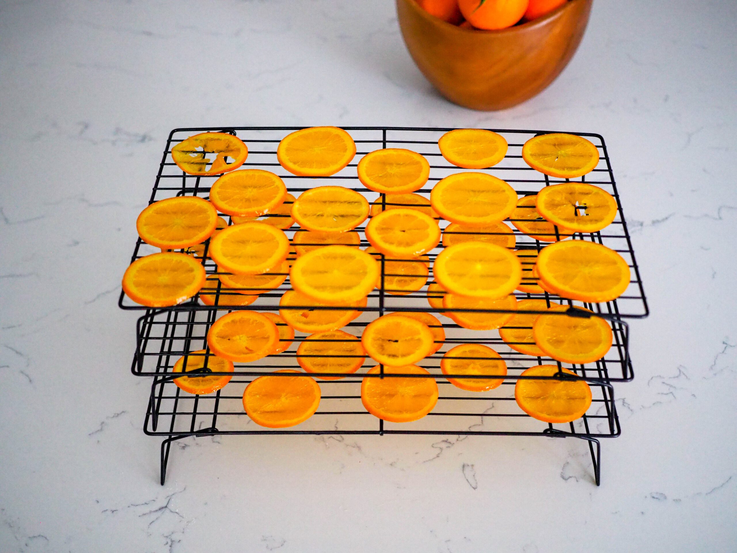 Stacked drying racks with orange slices on them.