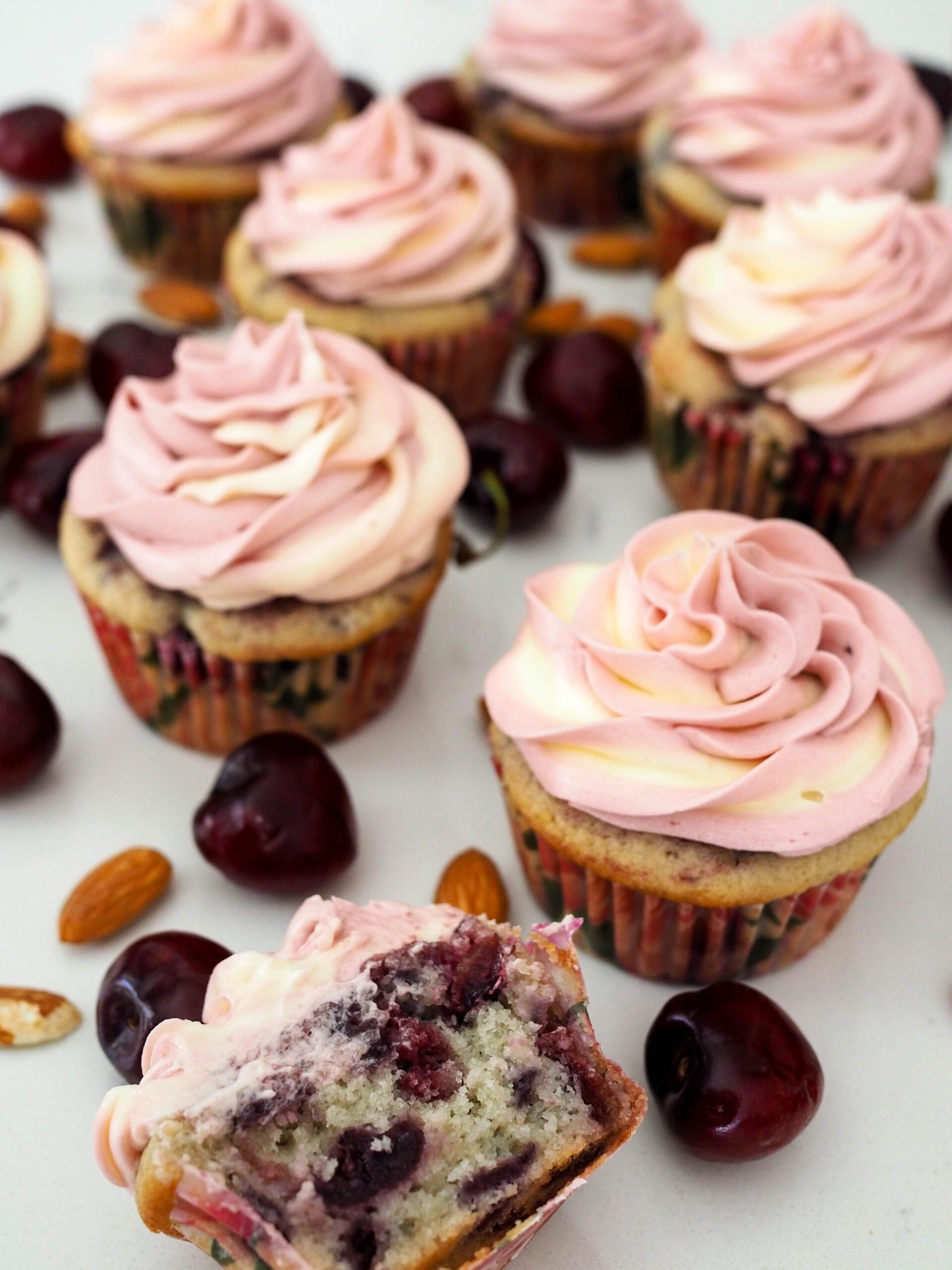 Cherry Almond Cupcakes are arranged on a white counter.