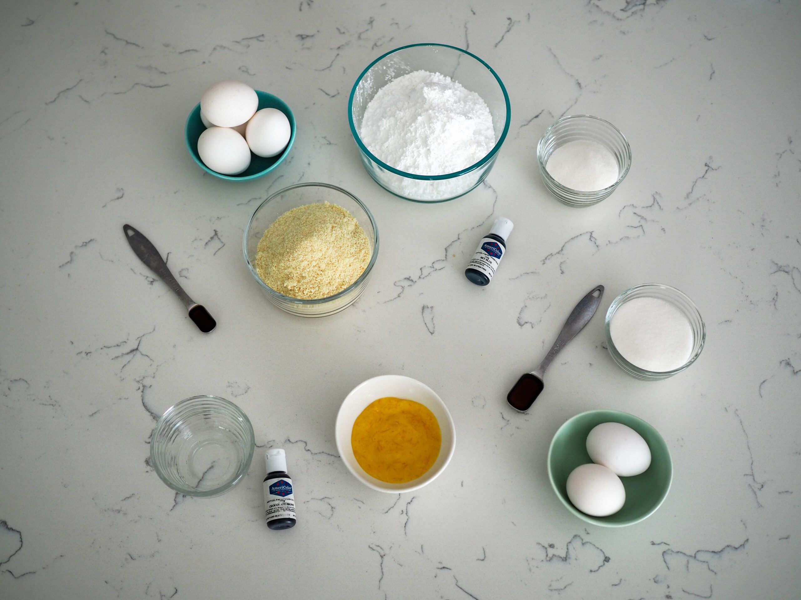 The ingredients for robin's egg macarons, laid out on a marblesque quartz countertop.