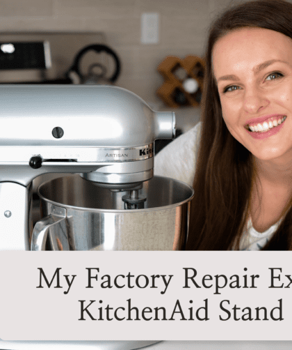 Alyssa, a white woman with brown hair, smiles at the camera with an arm around her metallic chrome KitchenAid stand mixer.