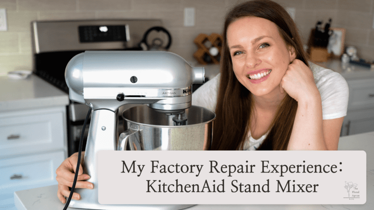 Alyssa, a white woman with brown hair, smiles at the camera with an arm around her metallic chrome KitchenAid stand mixer.