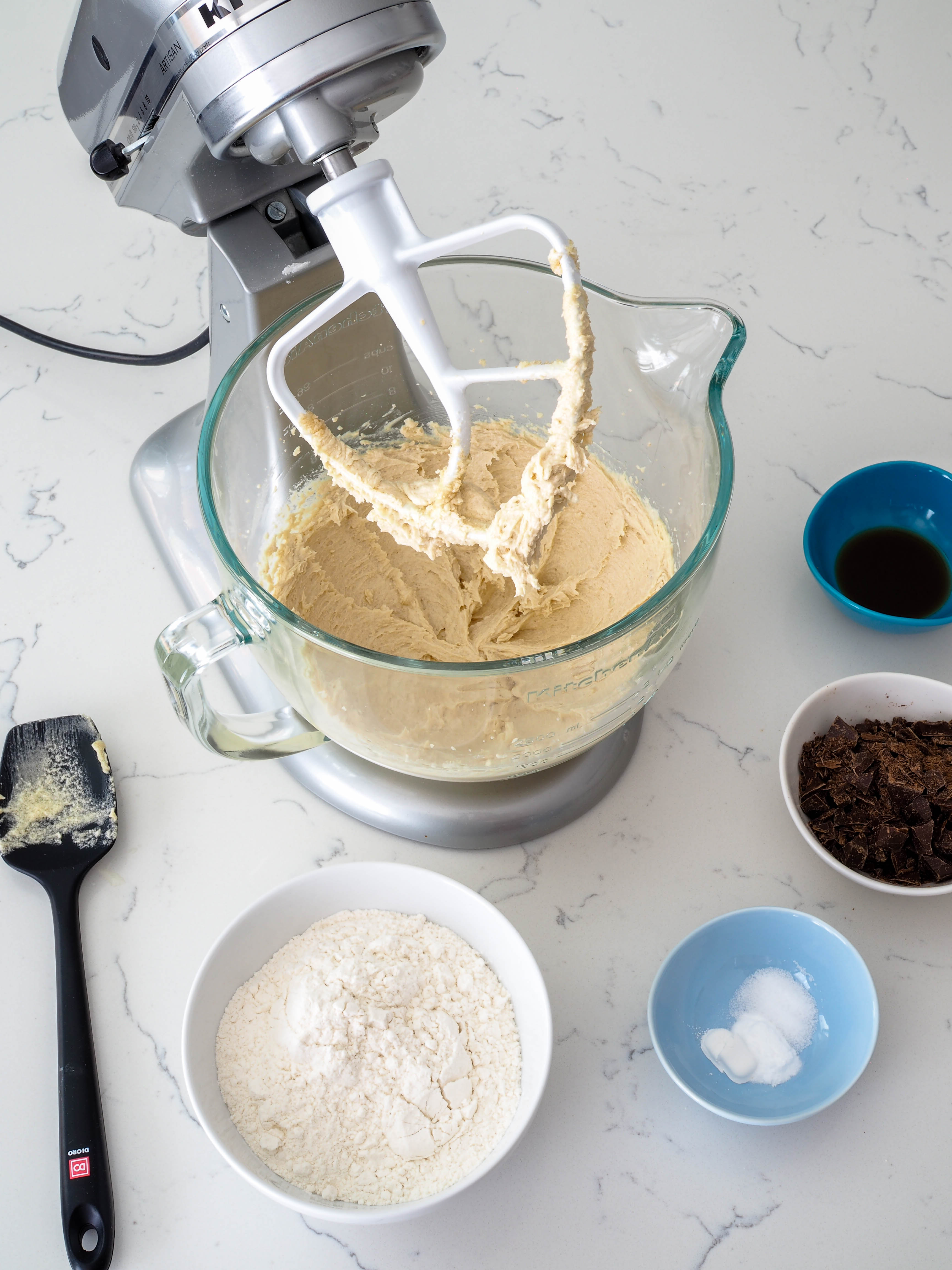 A bowl of cookie dough fitted in a stand mixer, just prior to adding the flour.