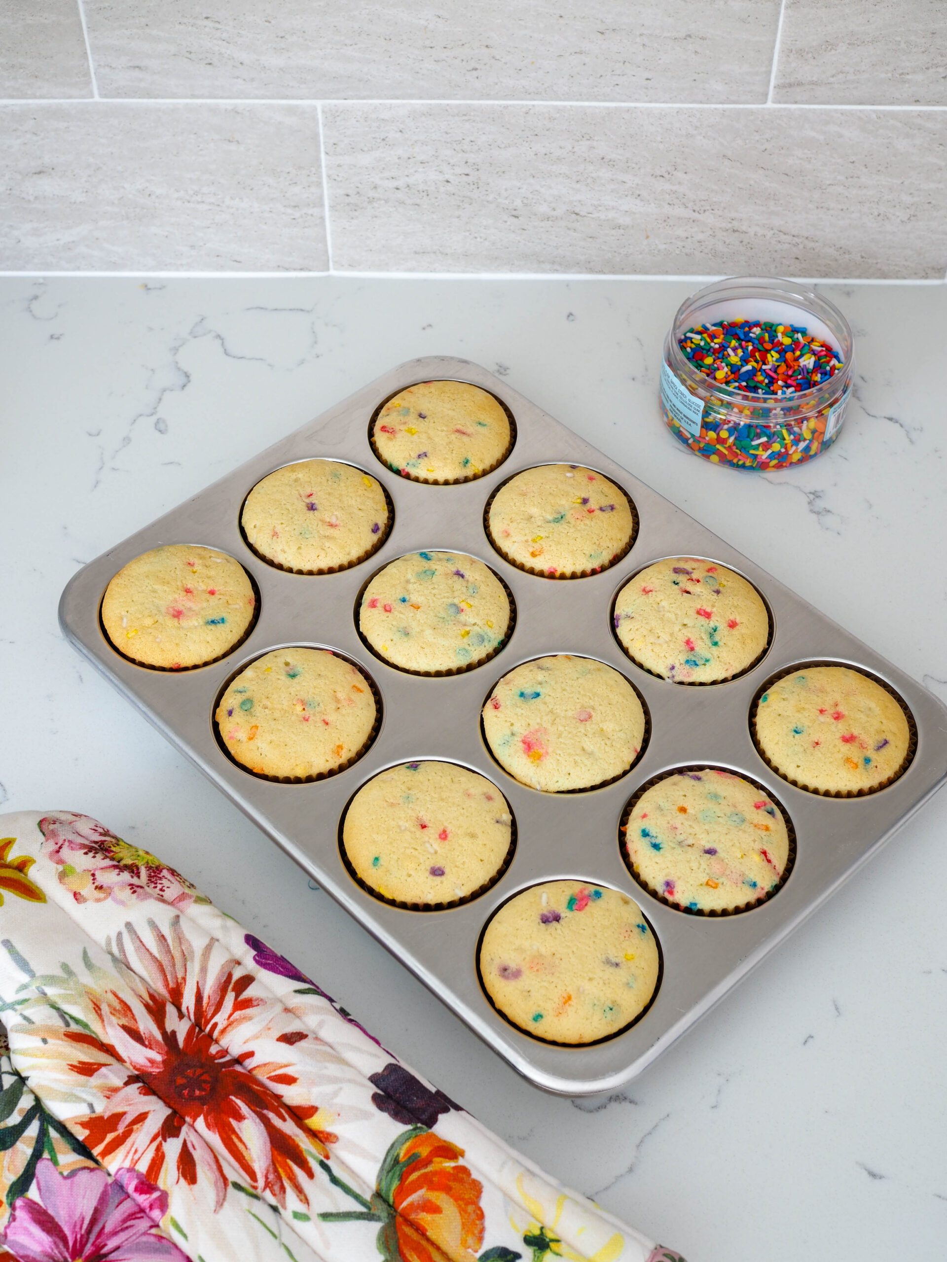 A batch of baked confetti cupcakes.
