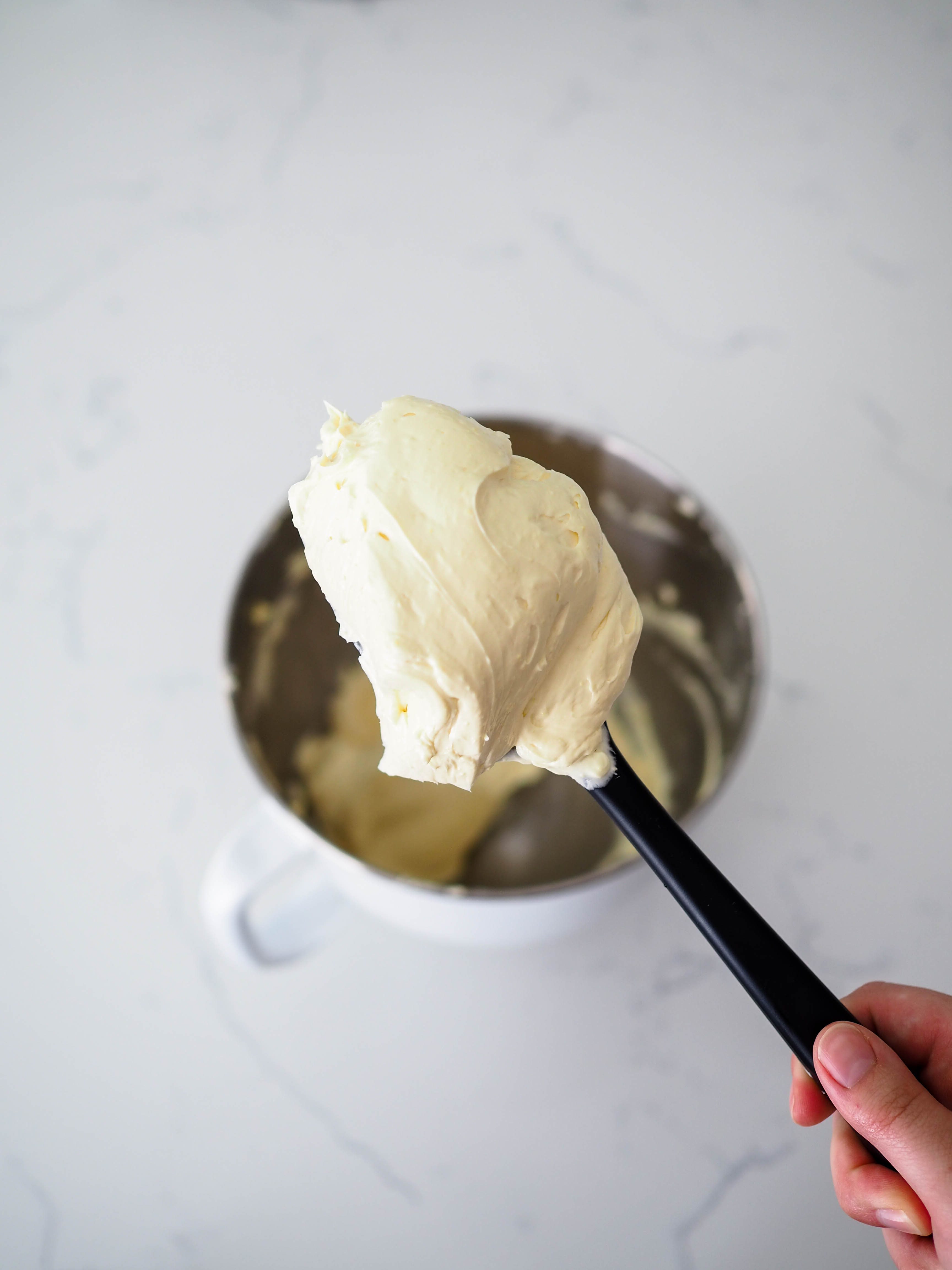 A large dollop of French buttercream on a spatula.