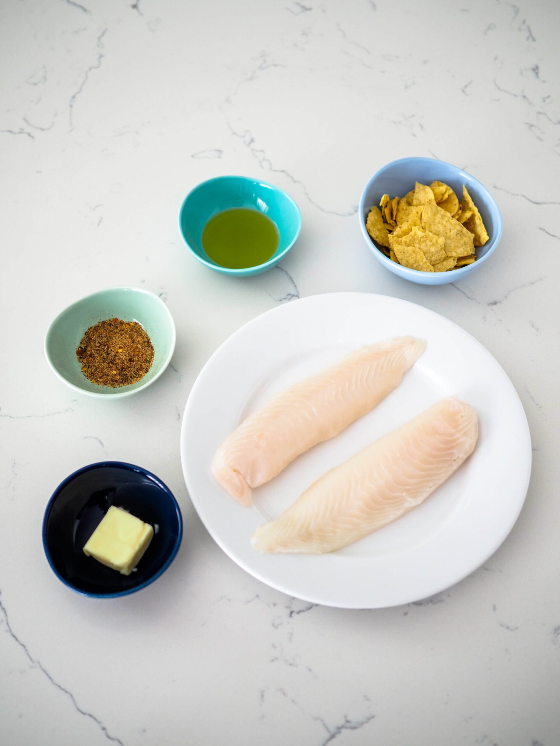 The five ingredients for cajun tortilla chip-crusted tilapia.