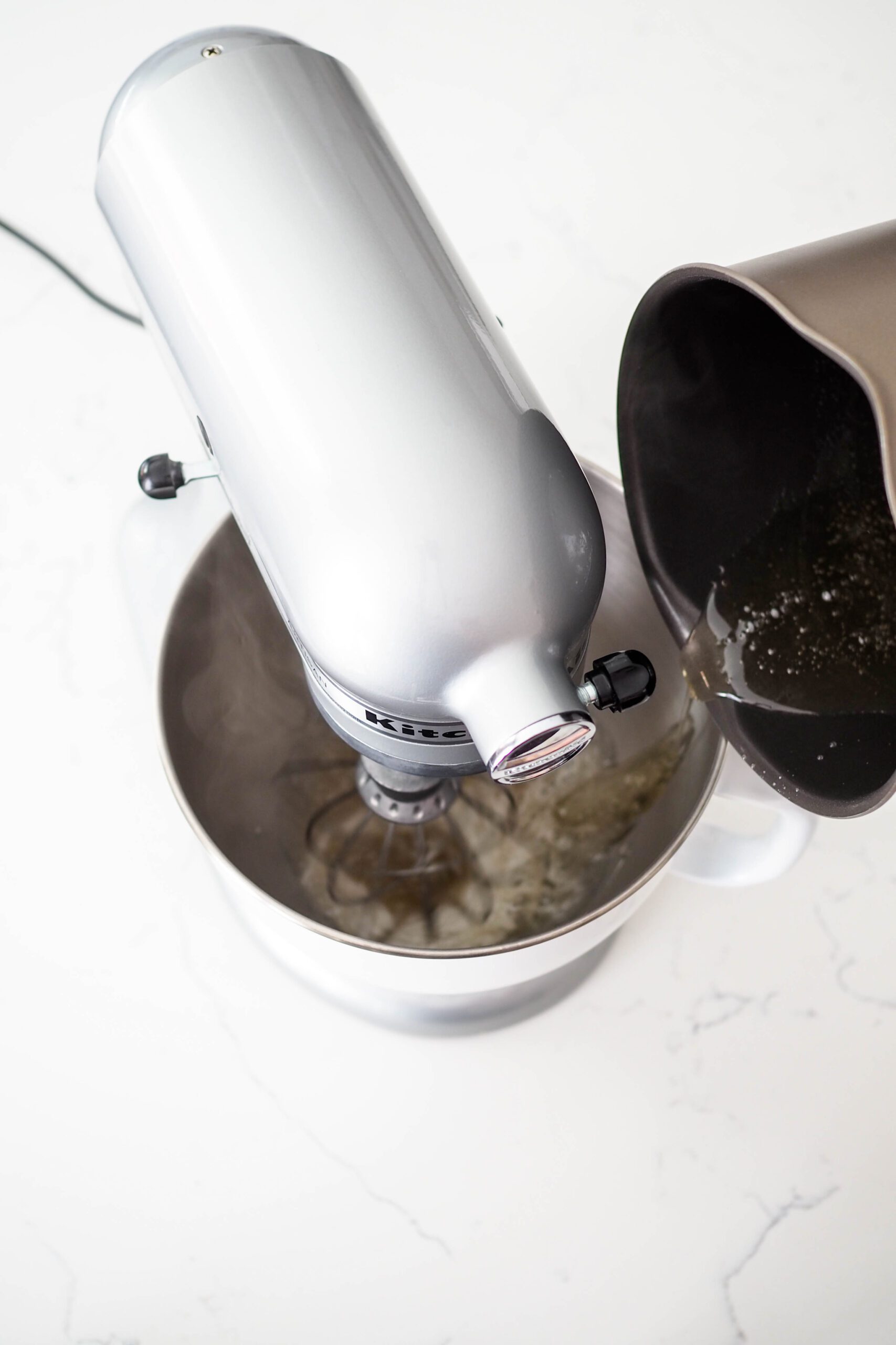 Sugar syrup carefully poured into a mixer bowl with the whisk going.