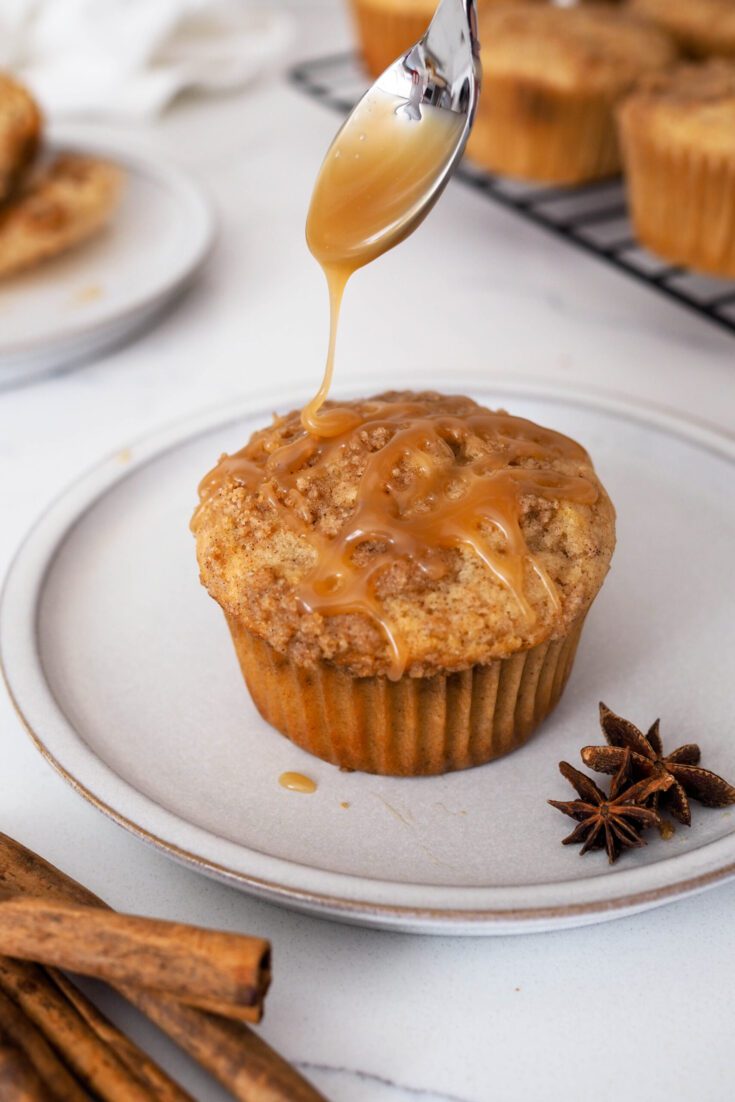 Salted caramel sauce is drizzled over a caramel chai muffin.