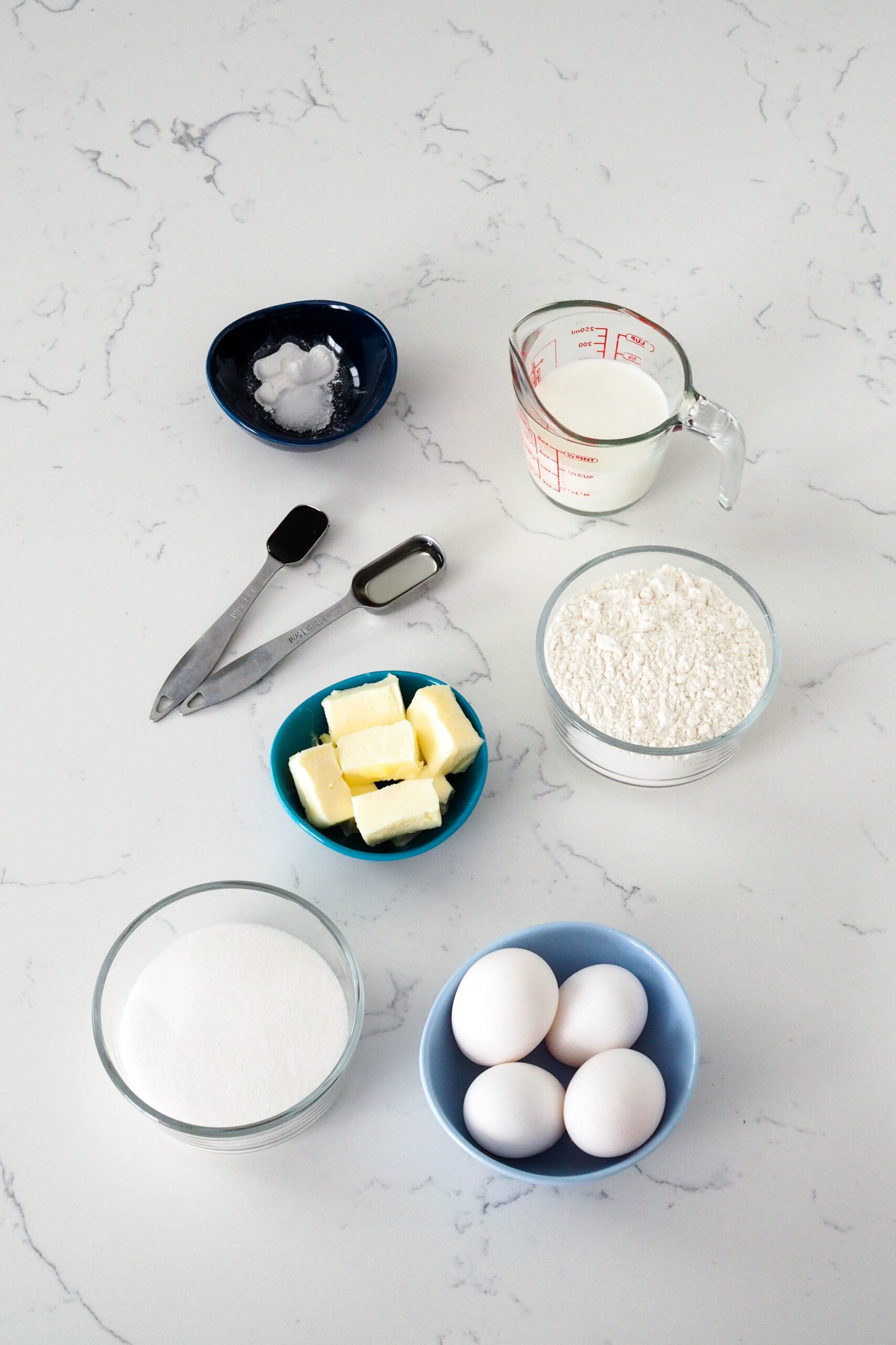 Ingredients needed to make the white cake laid out on a counter.