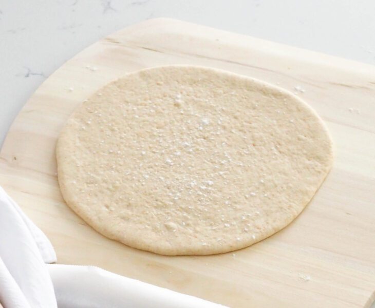 A pizza dough round on a pizza peel.