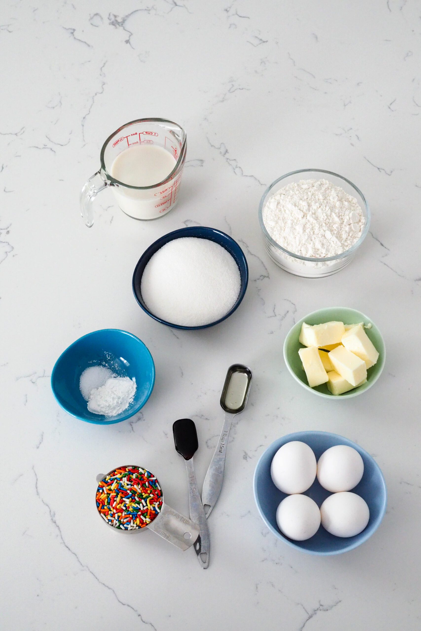 Ingredients needed to make the white sprinkle cakes.