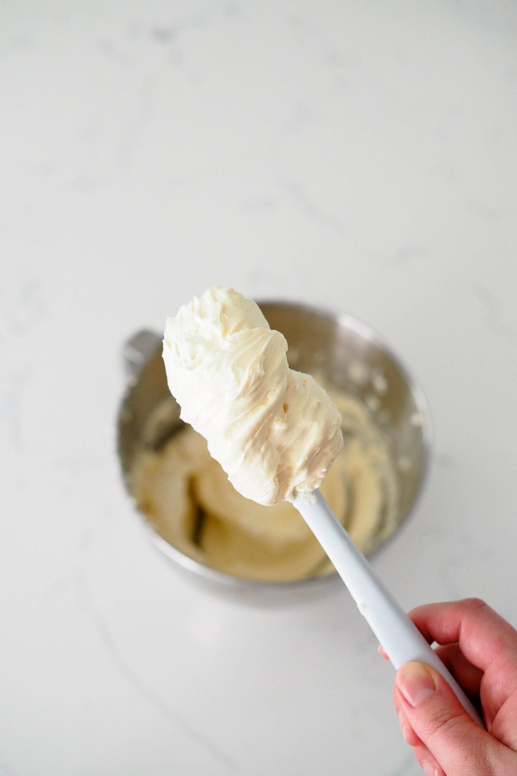 A small spatula holds up a load of silky French buttercream.