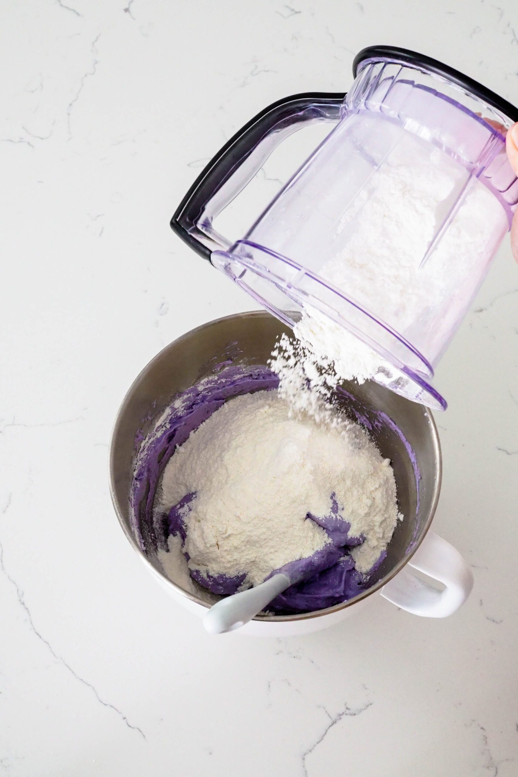 Almond flour and powdered sugar are added to a purple meringue.