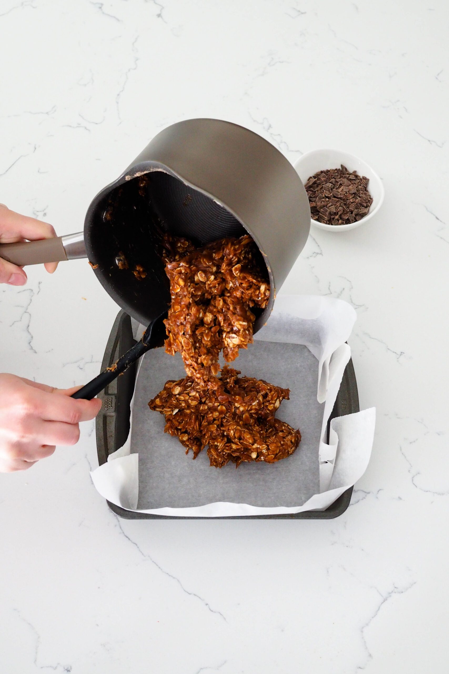 A spatula guides homemade protein bars out of a pan.