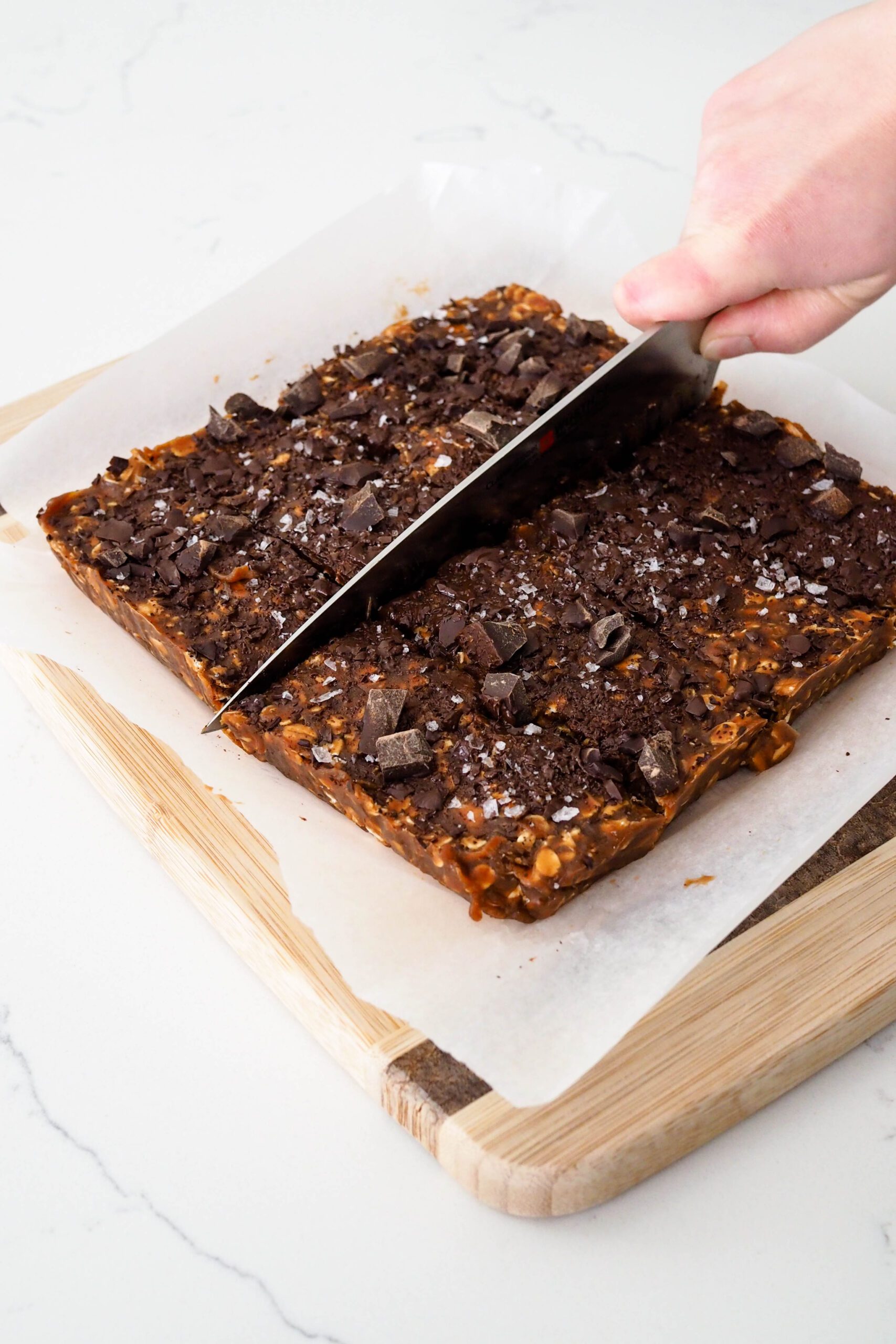 A knife cuts a bar of protein bars in half.