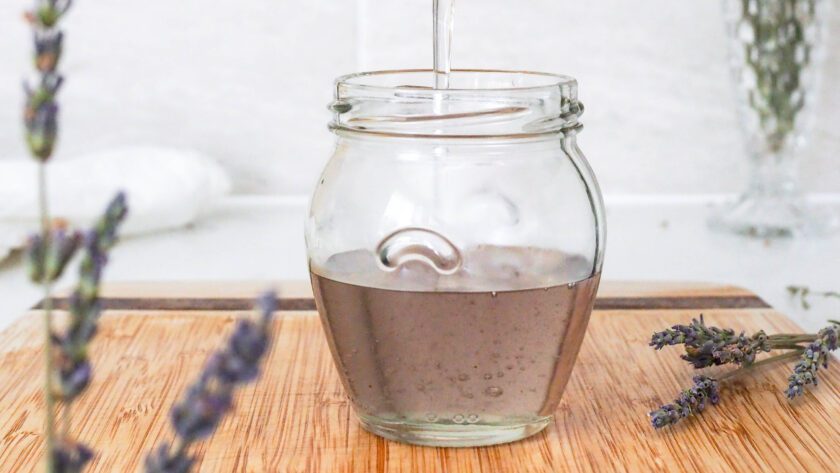 Lavender syrup is poured into a jar.