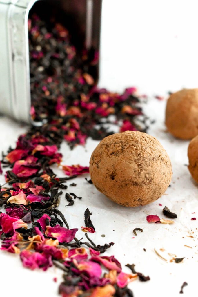 A truffle rolled in cocoa powder by Earl Grey tea with rose petals.