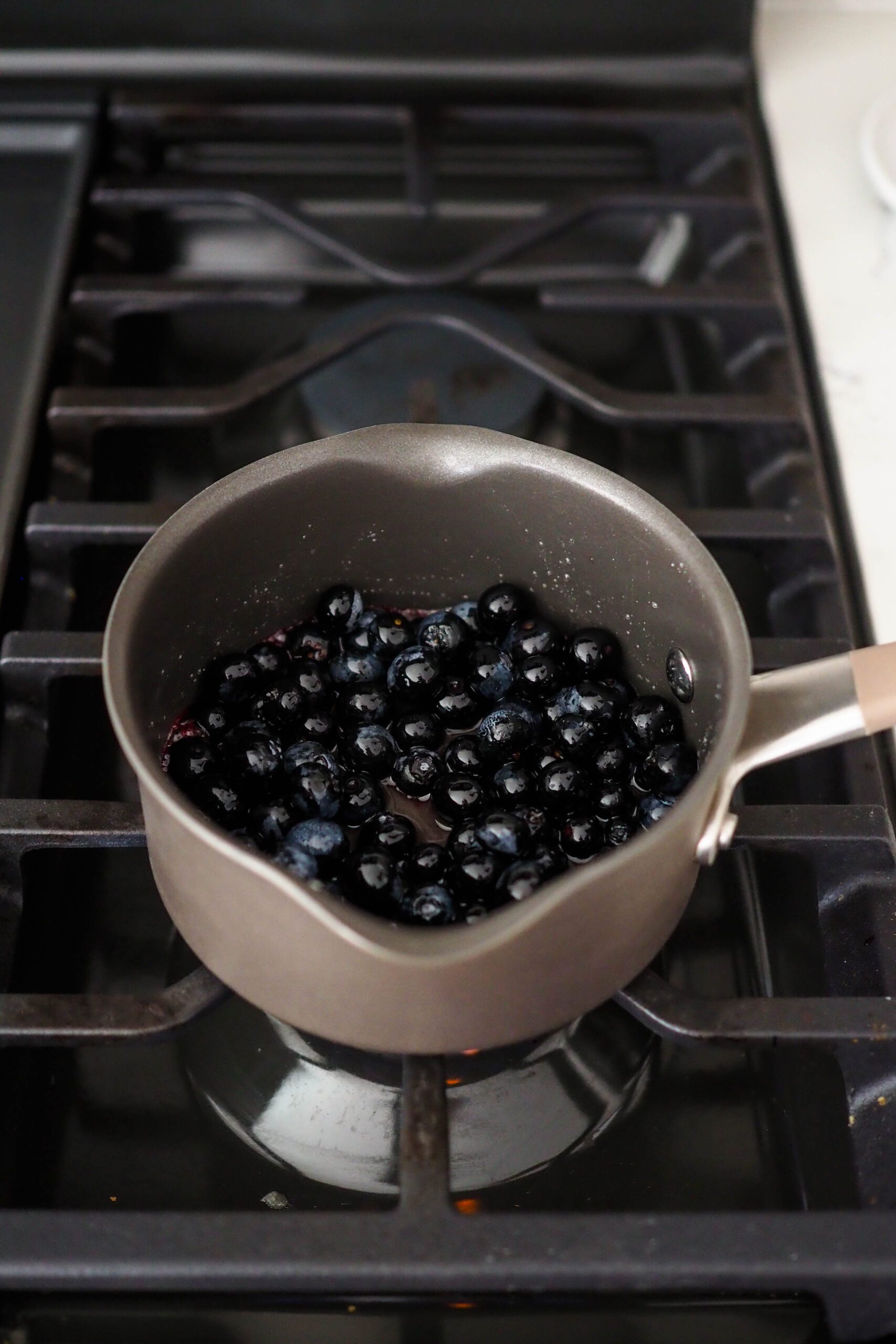 Blueberries in a small pot, darkened from the heat.