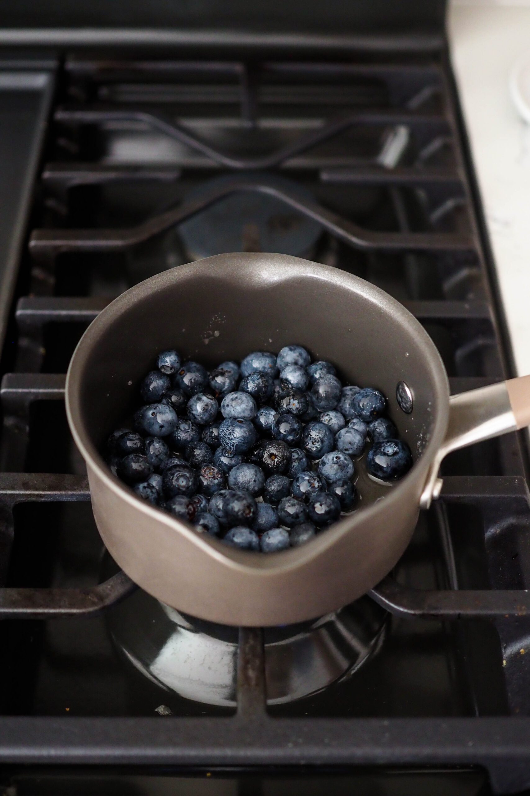 Blueberries in a small pot on the stove.