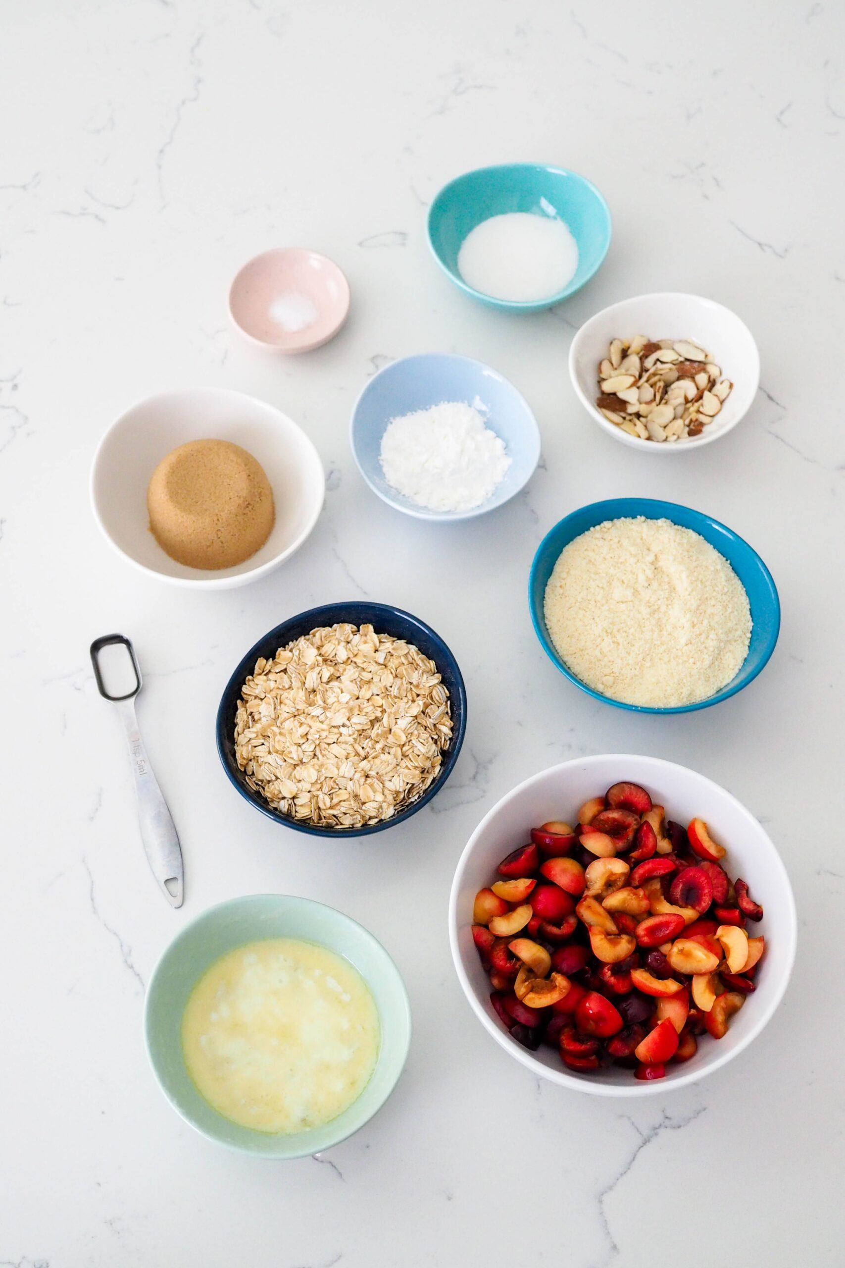 Ingredients for gluten-free cherry almond crumble on a countertop.