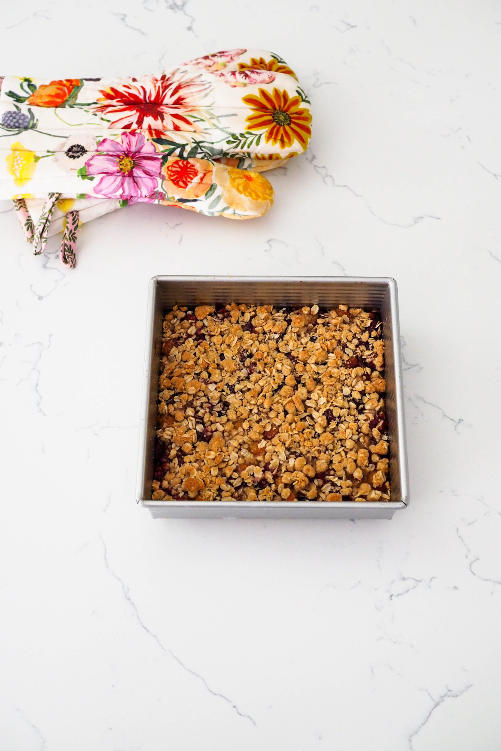 A fully-baked cherry crumble on a quartz counter.