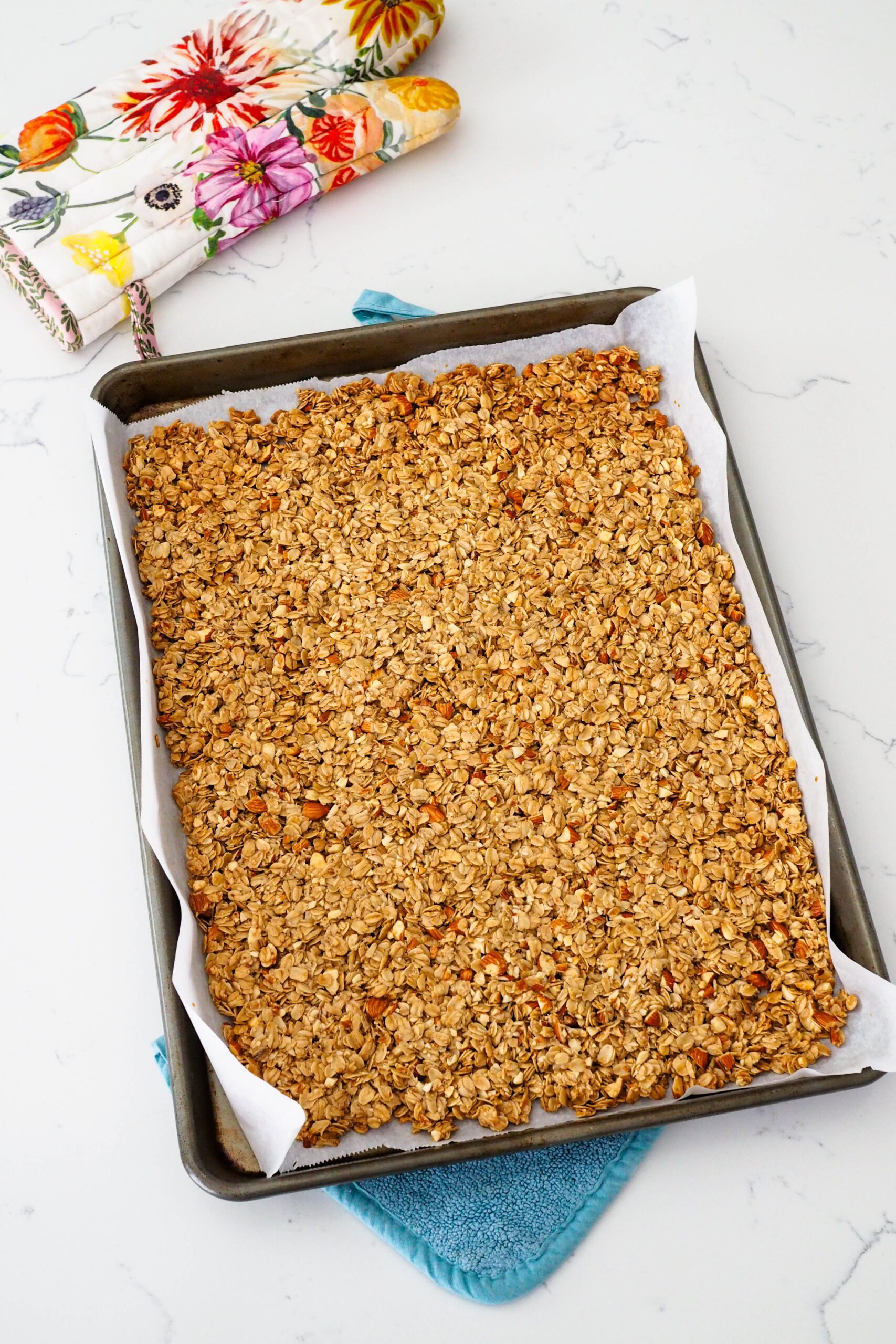 A thin layer of baked granola on a baking sheet.