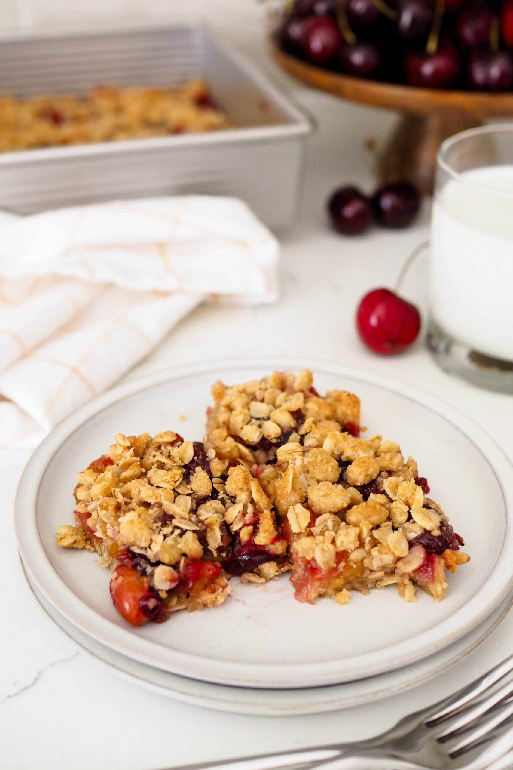 Three pieces of cherry crumble rest on a plate.