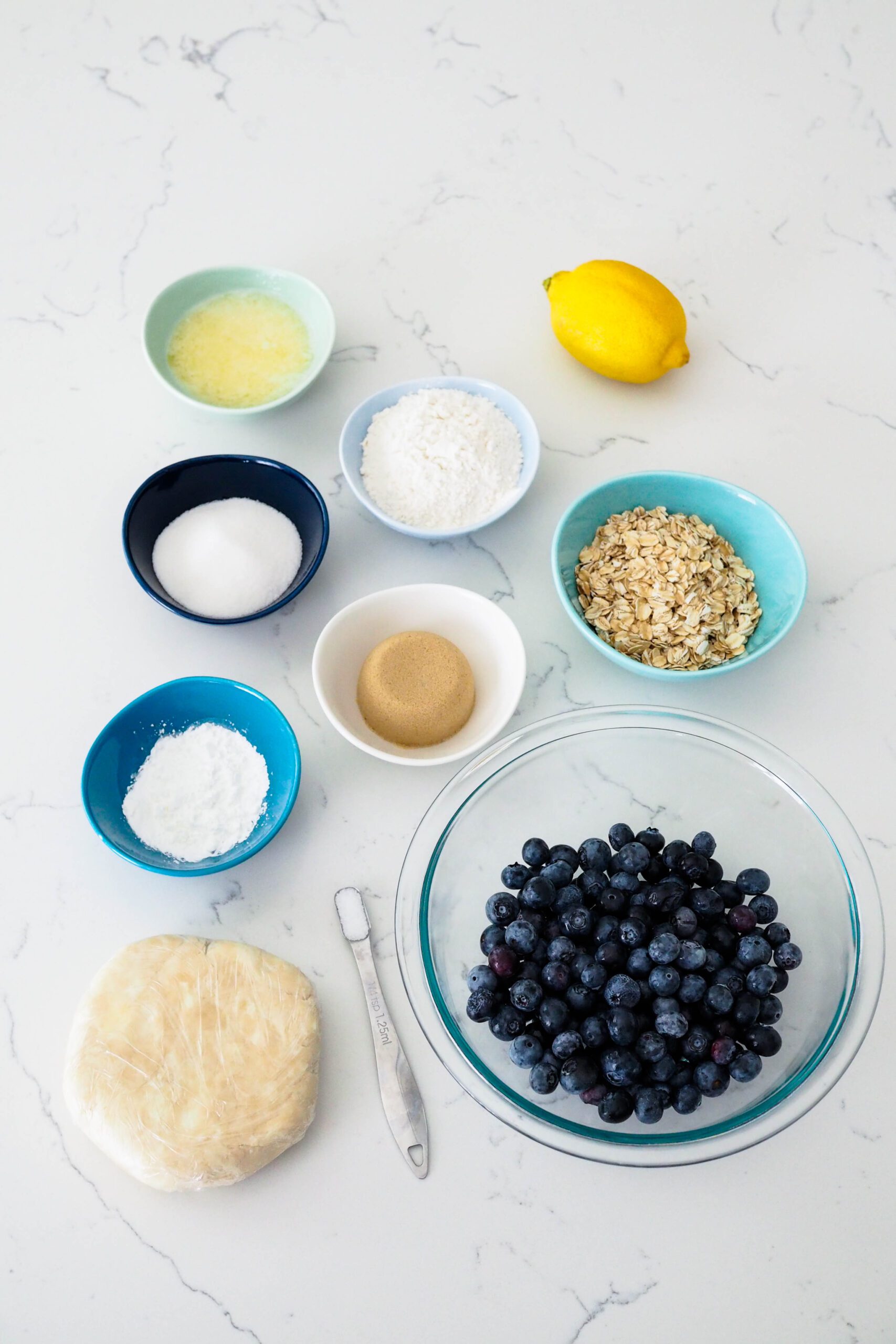 Ingredients for mini blueberry pies laid out on a counter.