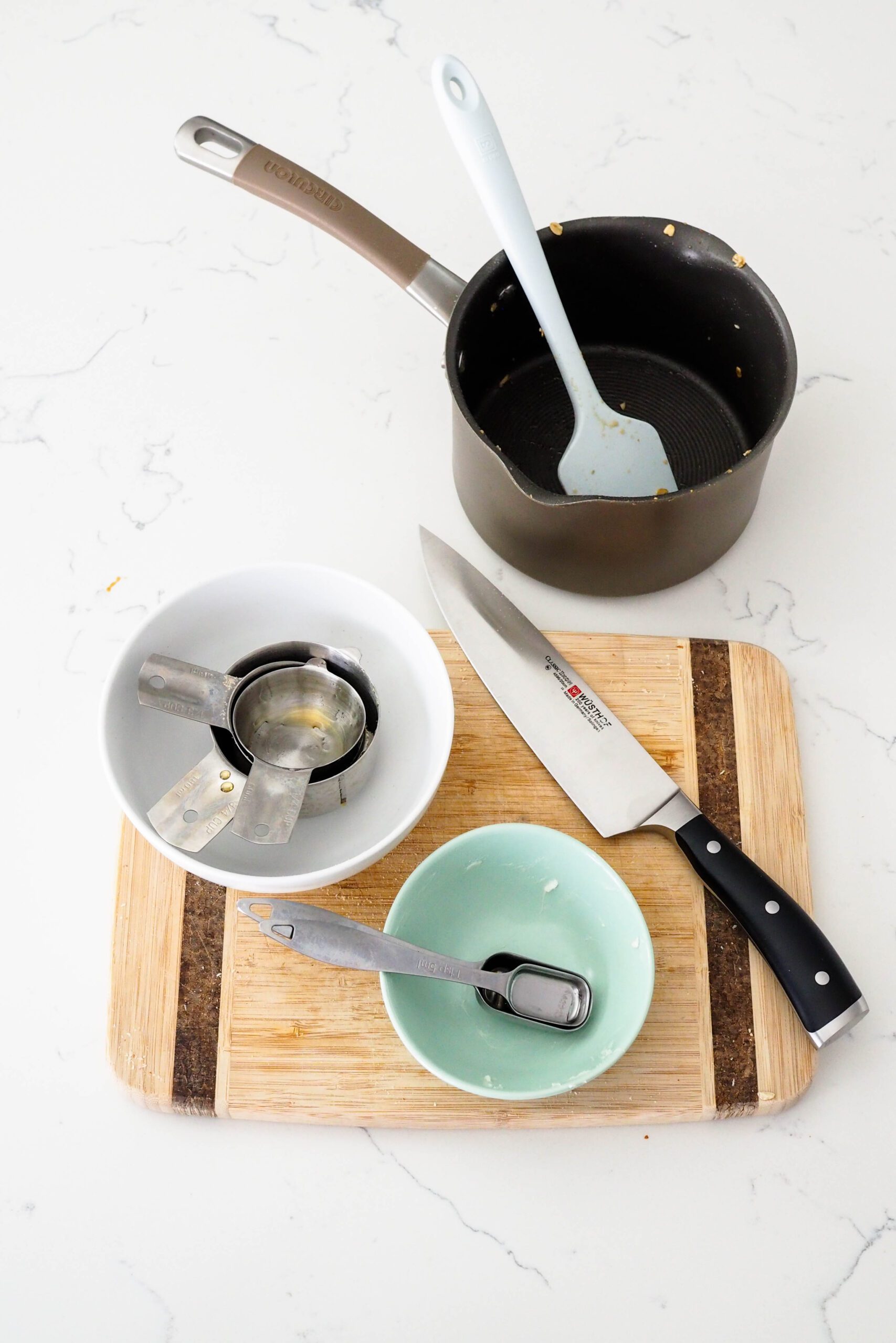 Dishes used to make vanilla almond granola on a quartz counter.
