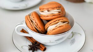 Chai macarons are piled in a tea cup.