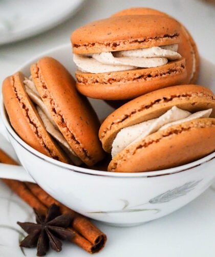 Chai macarons are piled in a tea cup.