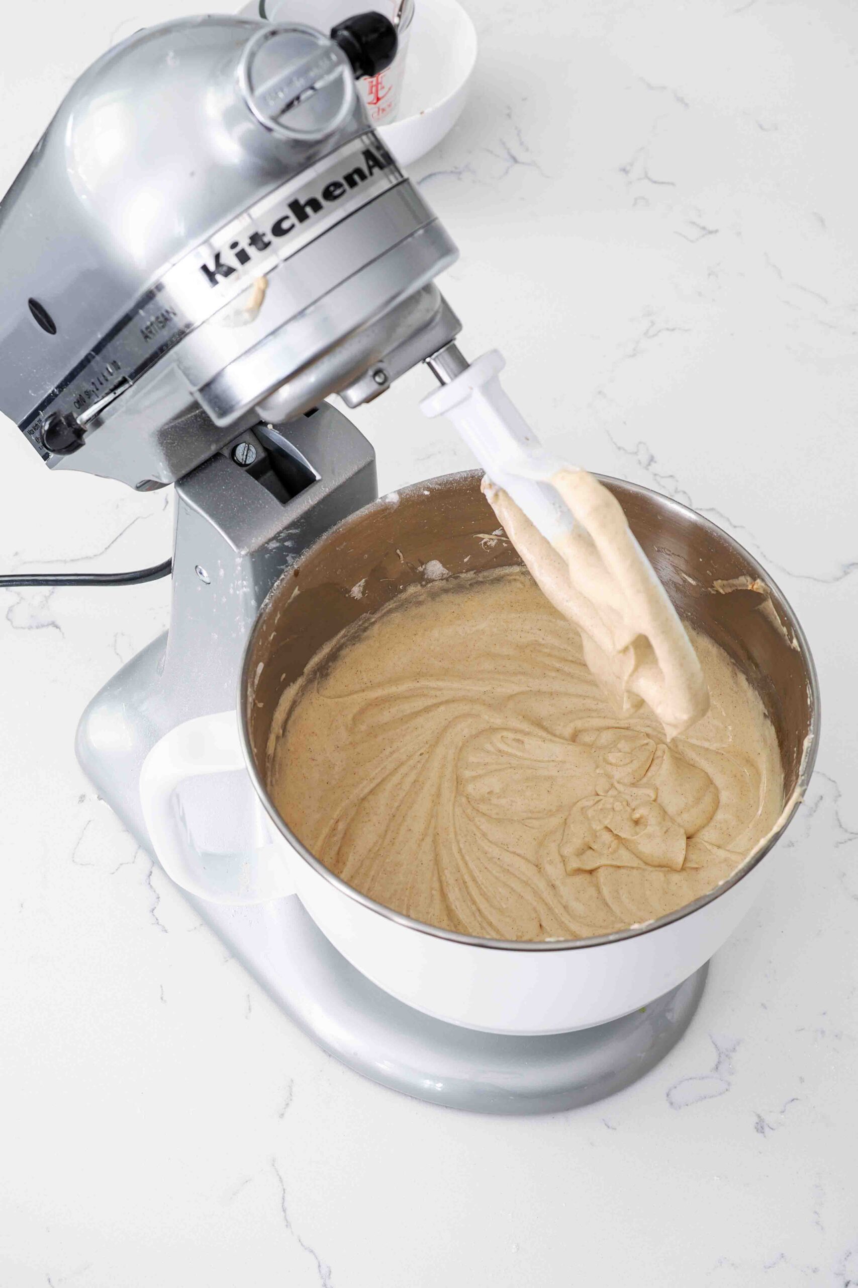 Cinnamon cake batter in a stand mixer bowl.