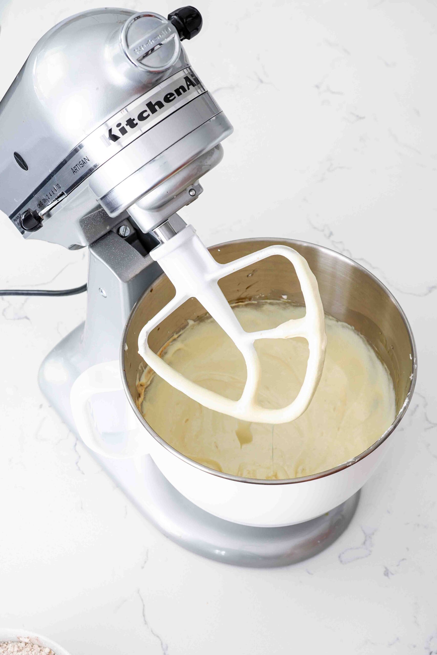 Butter, sugar, and eggs creamed together in a stand mixer bowl.