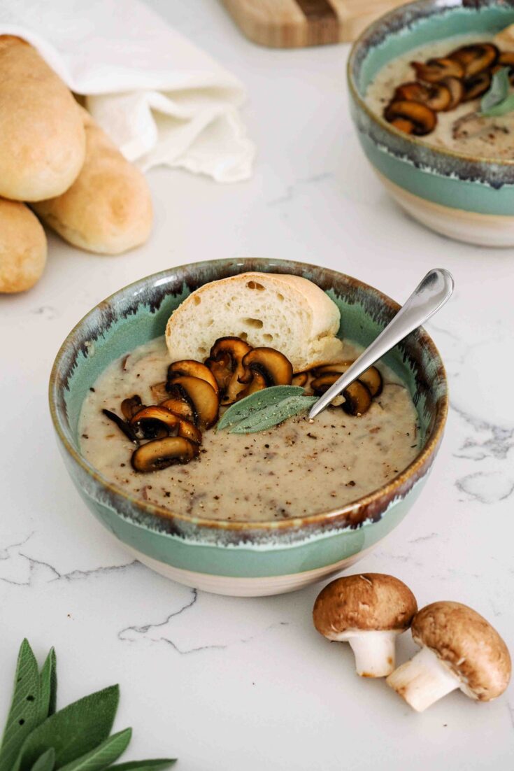 A bowl of mushroom potato soup topped with crispy mushrooms.