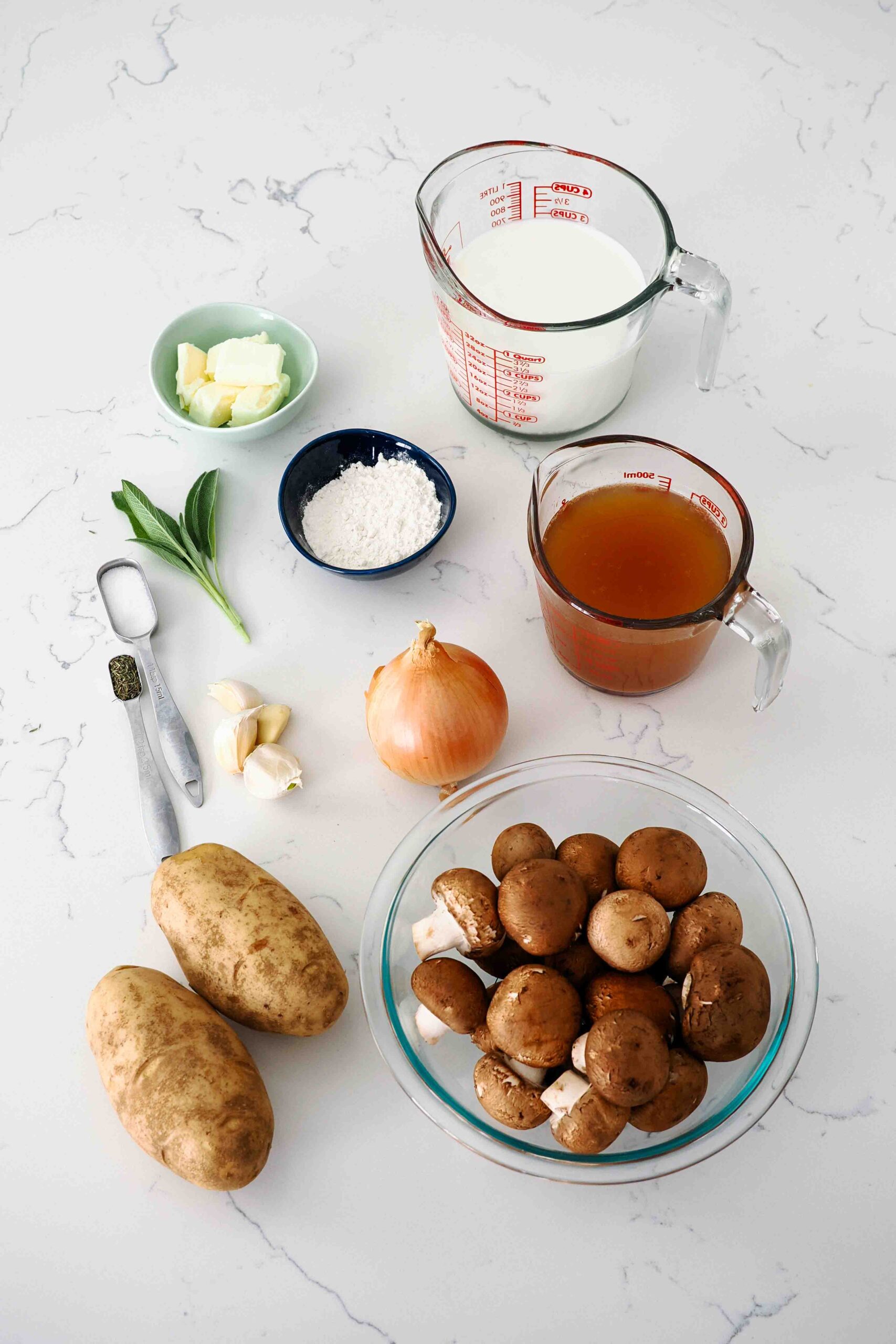 Ingredients needed to make potato mushroom soup on a counter.