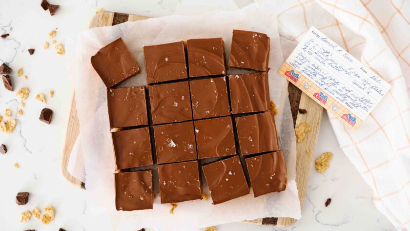 A batch of Special K bars on a cutting board with a handwritten recipe beside it.