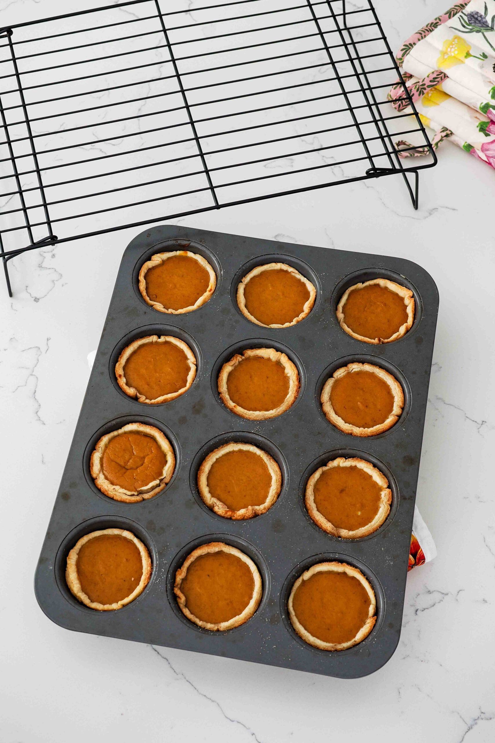 Baked mini pumpkin pies in a muffin pan straight out of the oven.
