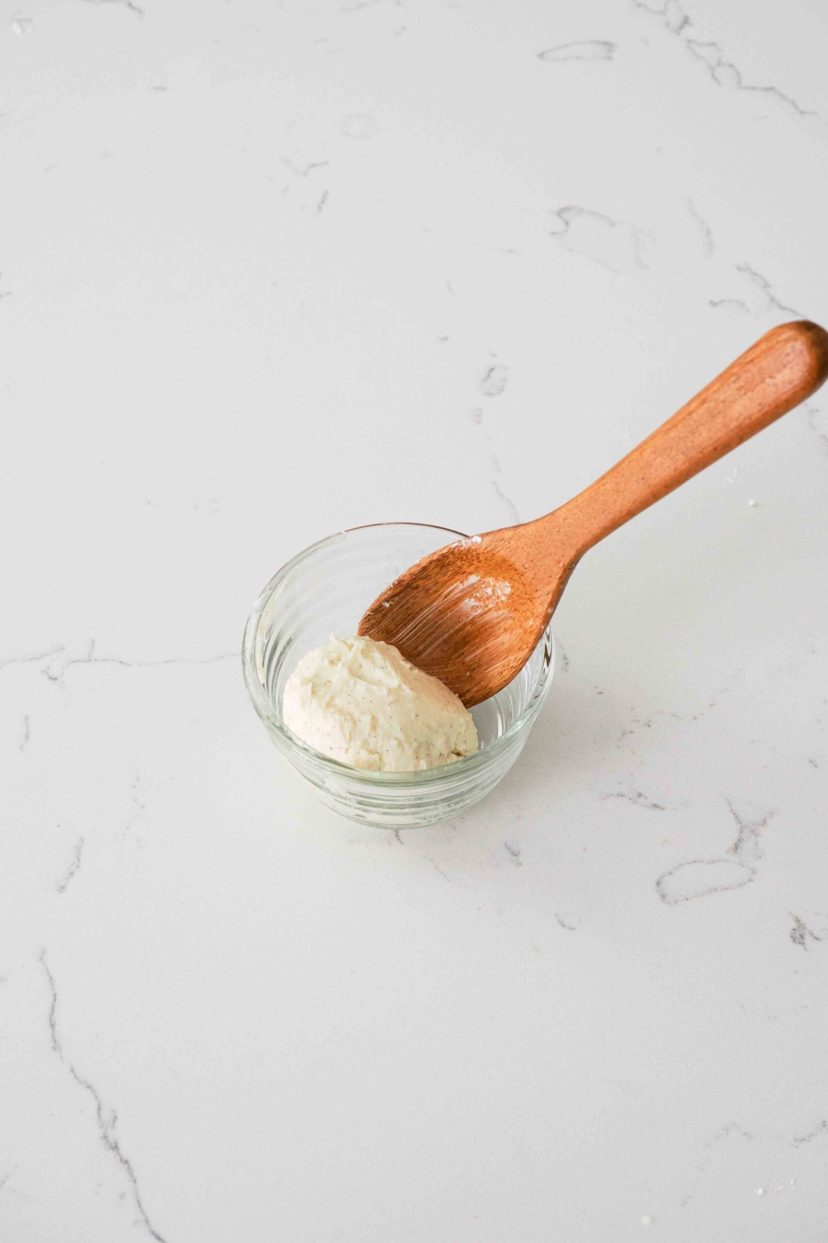 A wooden spoon with a sphere of vanilla bean-speckled homemade butter.