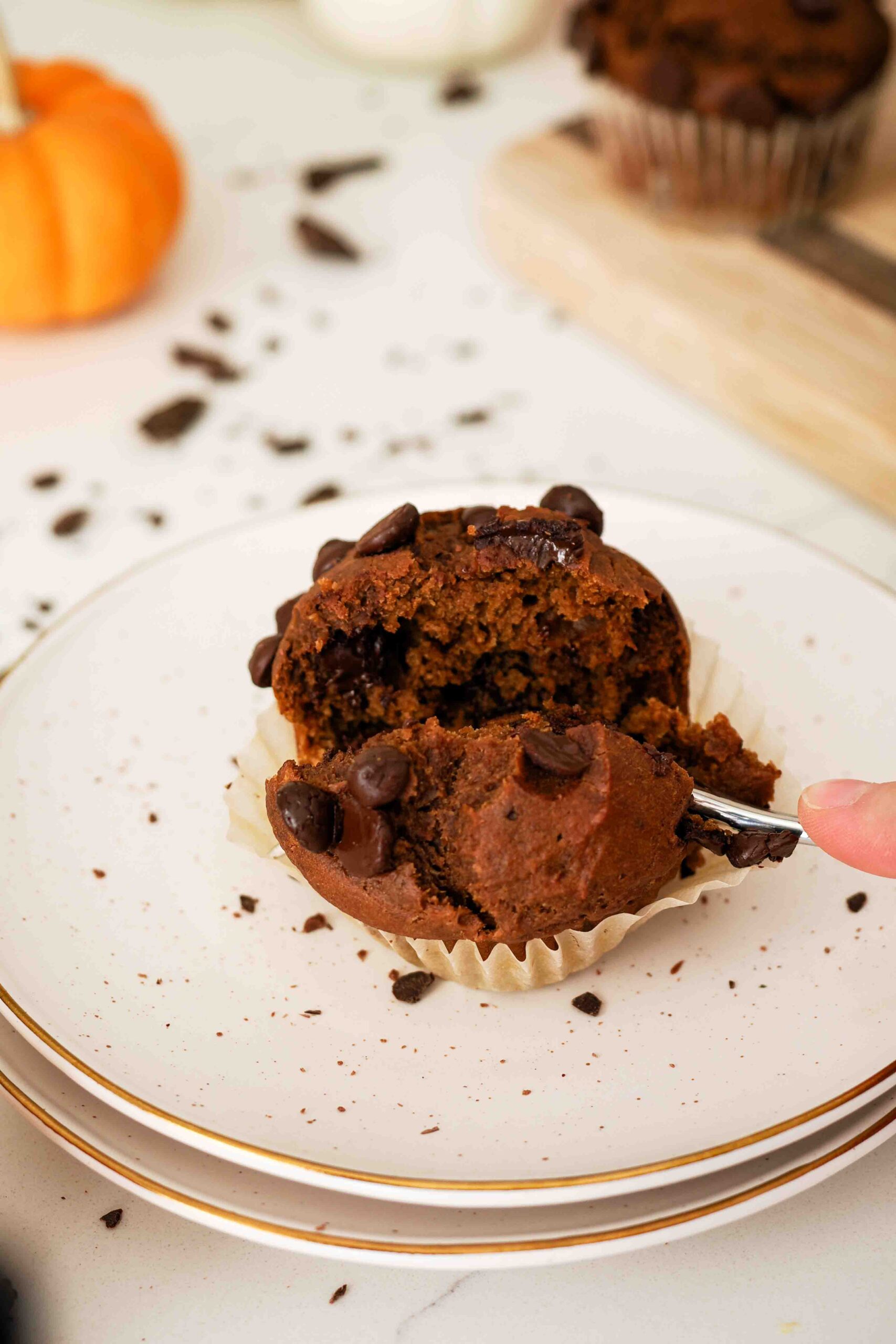A fork divides a chocolate pumpkin muffin in two.