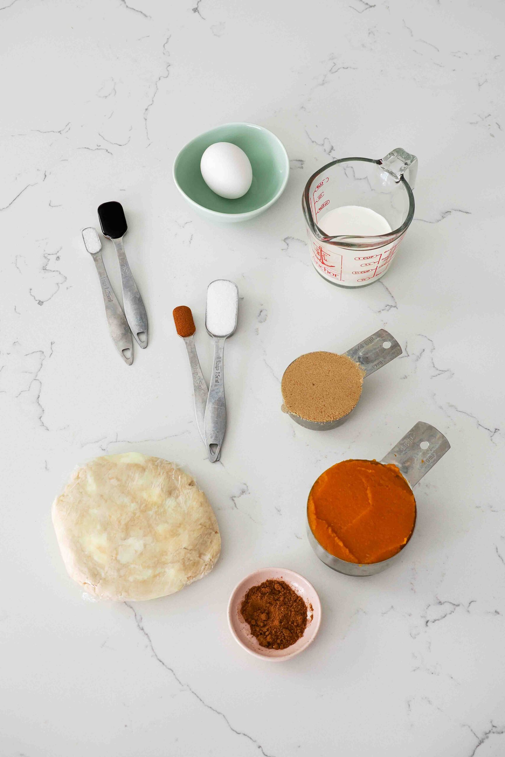 Ingredients for mini pumpkin pies on a quartz counter.