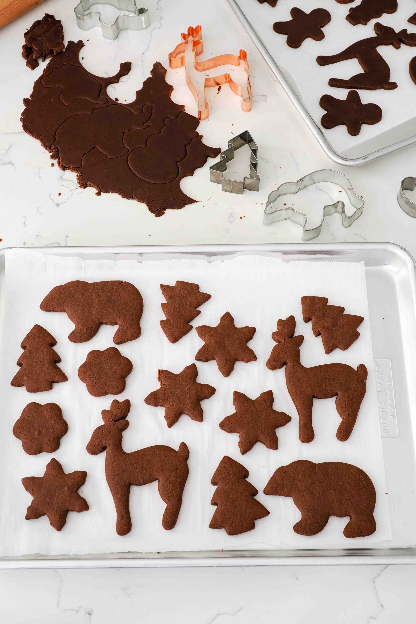 Baked chocolate gingerbread cookies on a baking sheet.
