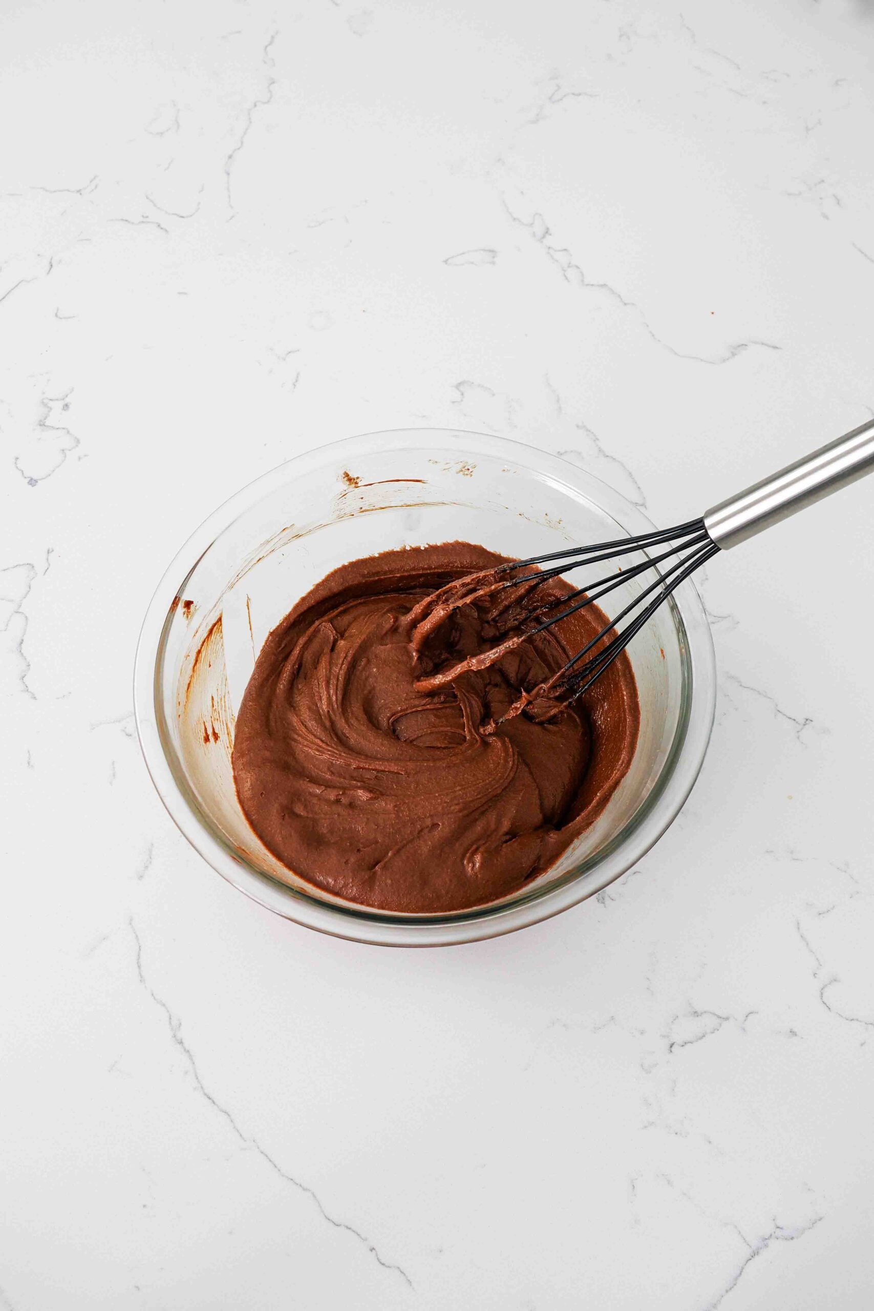 A whisk in a very thick chocolate batter.