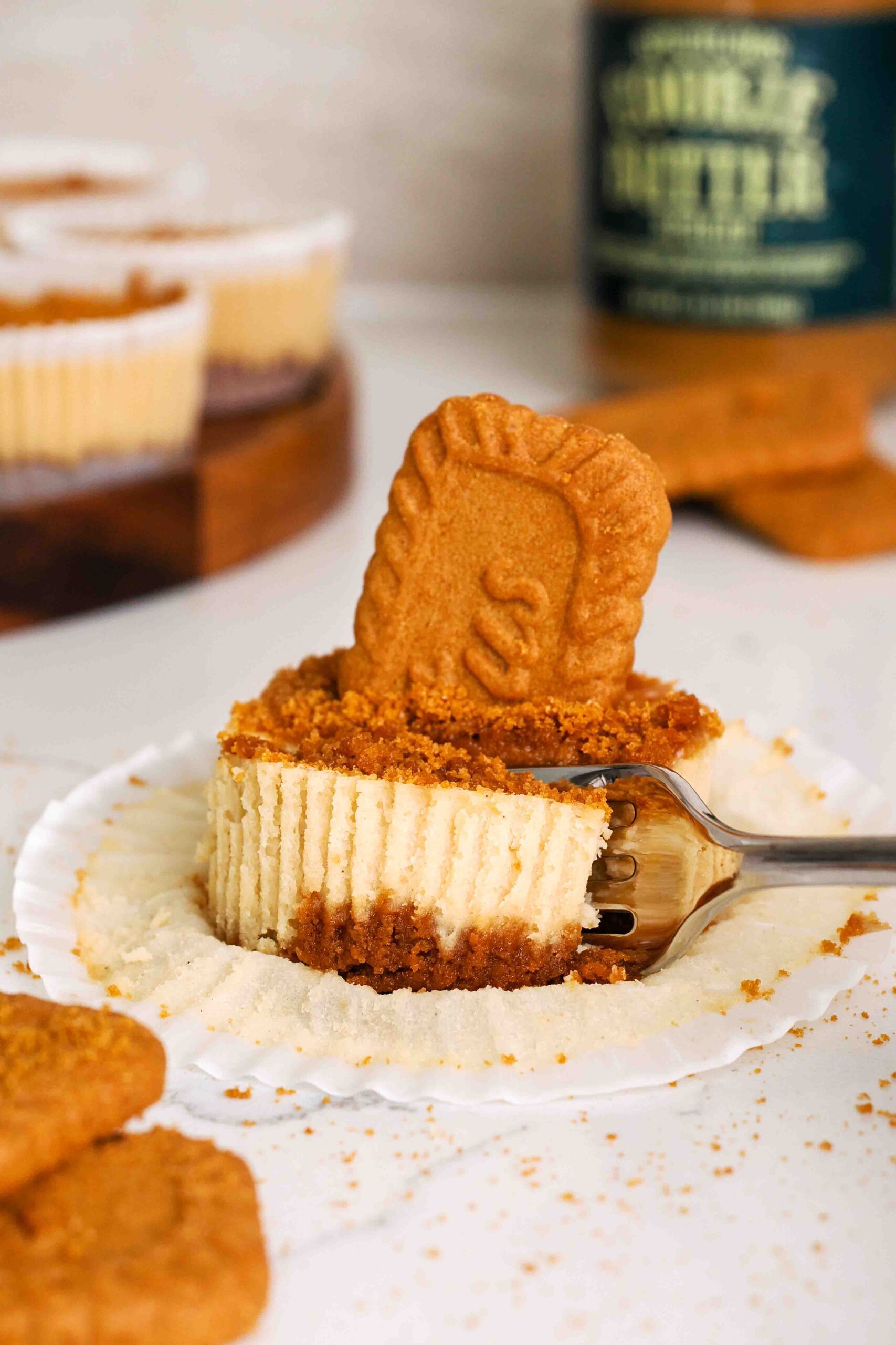 A fork cuts into a mini Biscoff cheesecake on a counter.