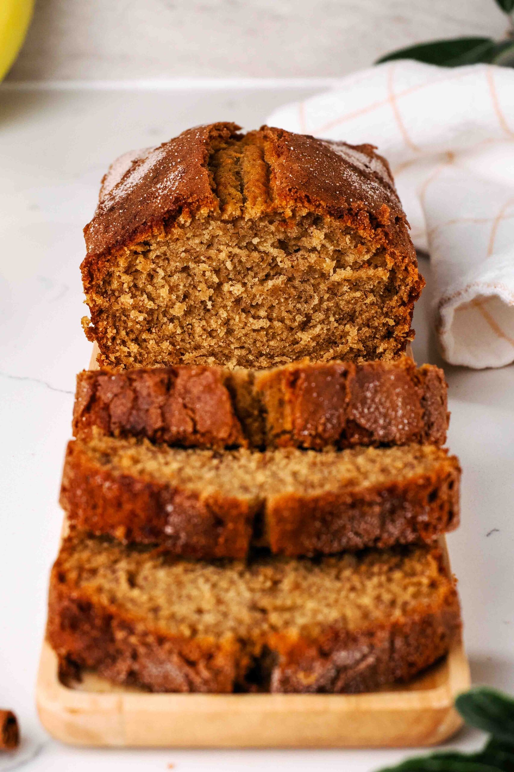 A sliced loaf of cinnamon banana bread with a crackly cinnamon sugar crust.
