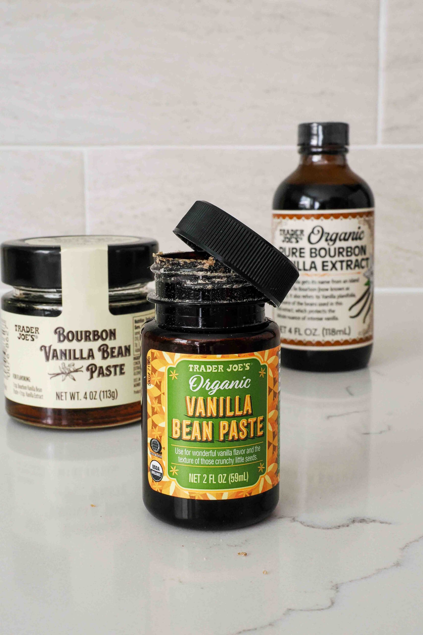 An opened jar of Trader Joe's organic vanilla bean paste with crystallization around the rim.
