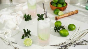 Pink lavender mojitos with mint and lavender sprigs on a white counter.
