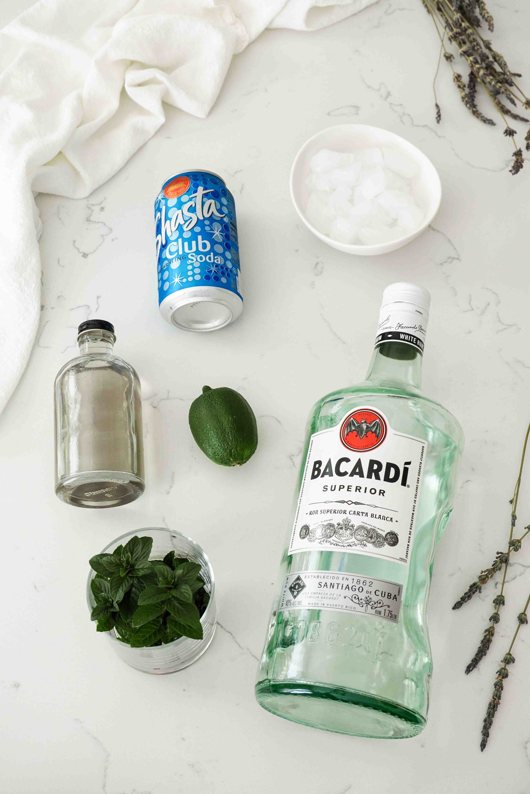 Ingredients needed to make a lavender mojito on a quartz counter.